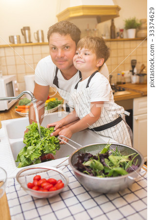 Father with son washes vegetables before eating Father with son washes vegetables before eating 33374629