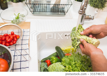 Man washes vegetables before eating 33374635
