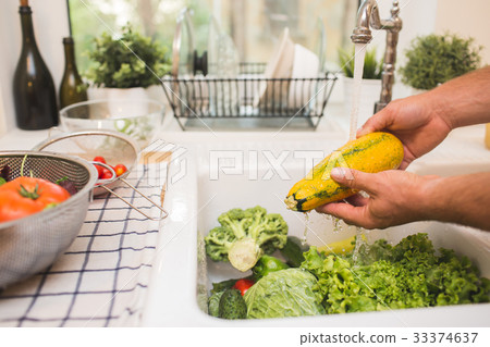 Man washes vegetables before eating 33374637