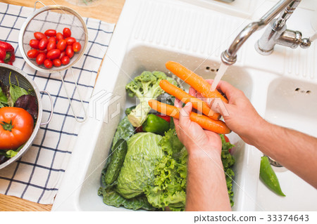 Man washes vegetables before eating 33374643