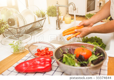 Man washes vegetables before eating 33374644