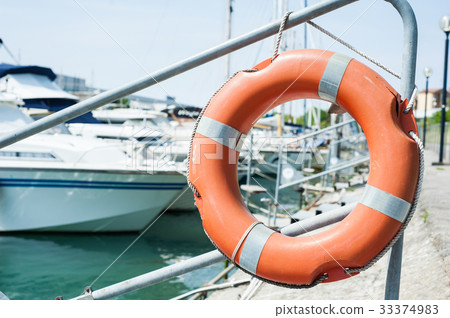 Life buoy hung on a railing in the port. Life buoy hung on a railing in the port. 33374983