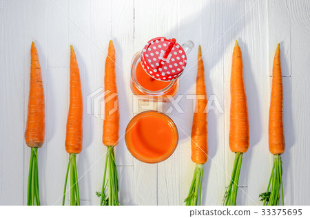 Carrot smoothie in a jar with carrots top view Carrot smoothie in a jar with carrots top view 33375695