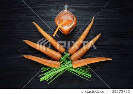 Carrot juice in a glass jar with handle on table Carrot juice in a glass jar with handle on table 33375700