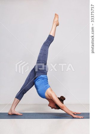 Woman doing Hatha yoga Eka pada adhomukha 33375757