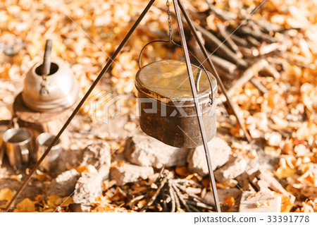 Cooking over a campfire in a cast iron pot. Cast 33391778
