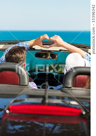 Happy young lover couple make heart shape on road 33396342