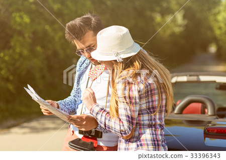 happy friends with map driving in cabriolet car at happy friends with map driving in cabriolet car at 33396343