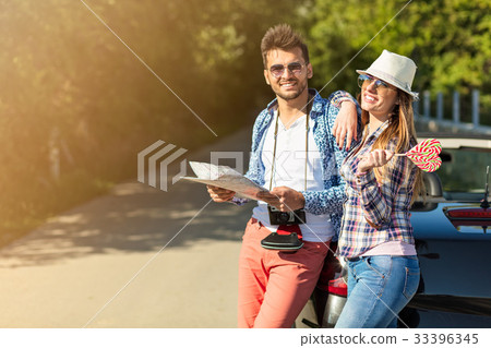 happy friends with map driving in cabriolet car at happy friends with map driving in cabriolet car at 33396345