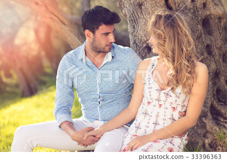 Loving young couple standing by trees at olive 33396363