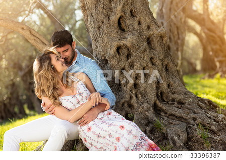 Loving young couple standing by trees at olive 33396387