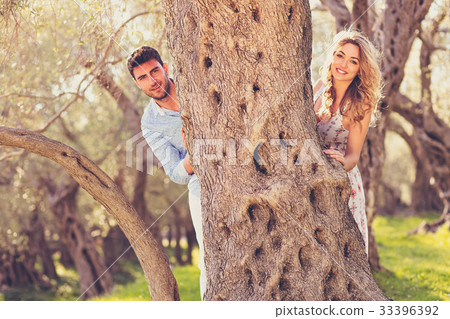Loving young couple standing by trees at olive 33396392