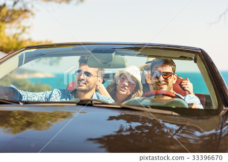 Group of cheerful young friends driving car and Group of cheerful young friends driving car and 33396670