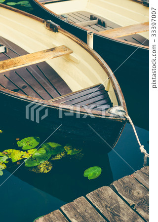 Wooden pleasure rowboat at the pier of a lake for 33397007
