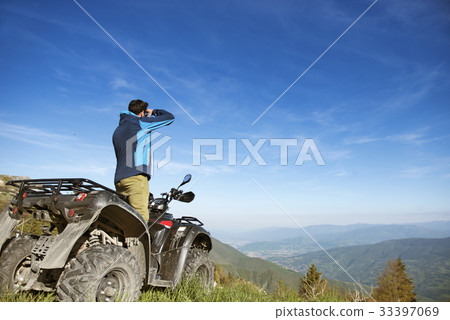 Man on the ATV Quad Bike on the mountains road. 33397069