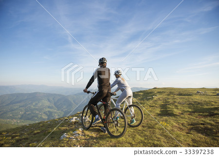 Cyclist couple with mountain bikes standing on the 33397238