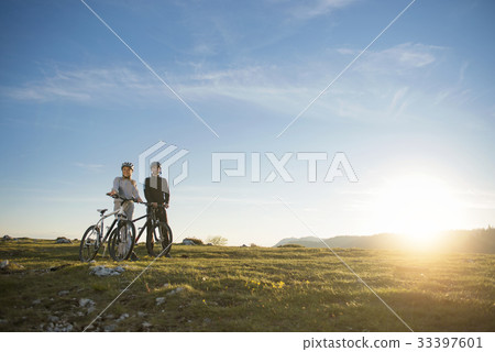 Cyclist couple with mountain bikes standing on the Cyclist couple with mountain bikes standing on the 33397601