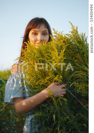 Funny girl in dress with bouquet of field flowers Funny girl in dress with bouquet of field flowers 33400494