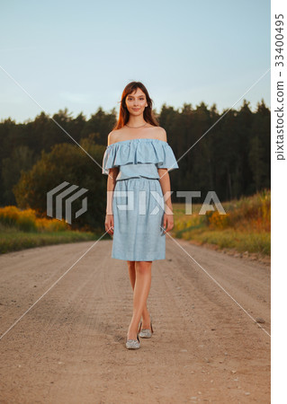 Pretty girl walking on country road in sunset Pretty girl walking on country road in sunset 33400495