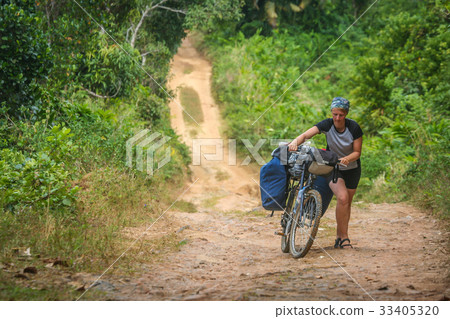 Pushing bicycle on a jungle path Pushing bicycle on a jungle path 33405320