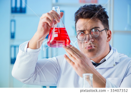 Funny mad chemist working in a laboratory 33407352