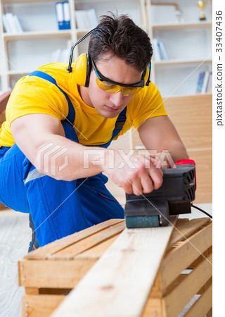 Repairman carpenter polishing a wooden board with Repairman carpenter polishing a wooden board with 33407436