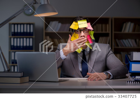 Businessman staying late to sort out priorities Businessman staying late to sort out priorities 33407725