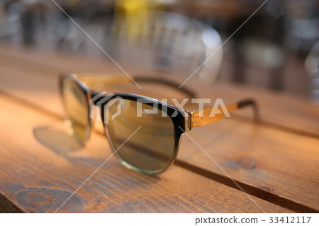Sunglasses on wooden bench. Close up 33412117