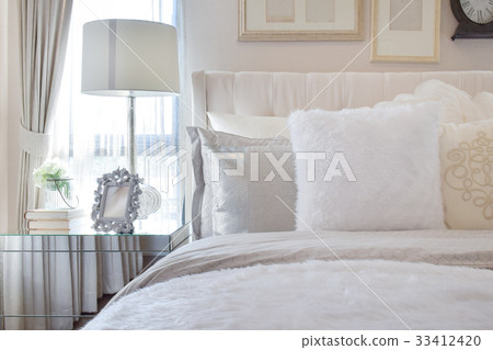 white lamp with picture frame on bedside table 33412420