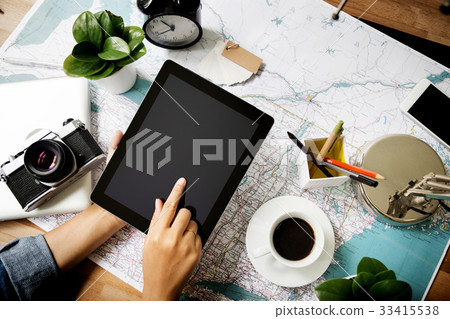 Touching tablet device above map at work place Touching tablet device above map at work place 33415538