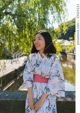 an asian young woman smiling and wearing Yukata 33424152
