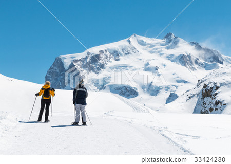 two people are trekking on the snow mountain two people are trekking on the snow mountain 33424280