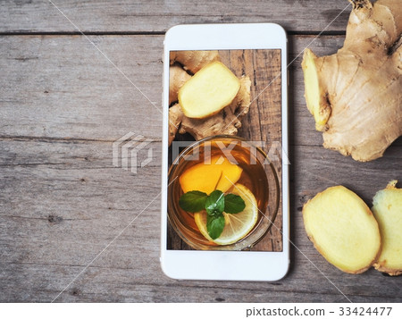 Taking a photo of ginger tea with smart phone Taking a photo of ginger tea with smart phone 33424477