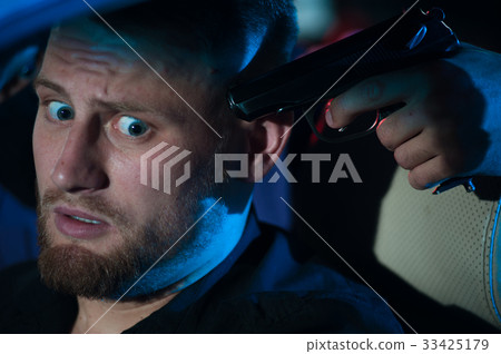 Criminal person pointing gun at the driver 33425179