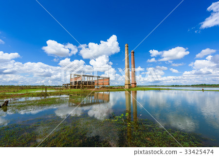 Old mill in the reservoir against blue sky Old mill in the reservoir against blue sky 33425474