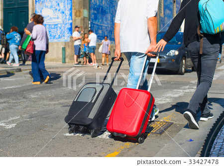 Tourists carrying bags on street 33427478