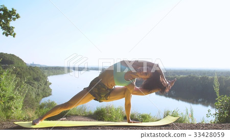 Happy young woman practicing yoga at sunset Happy young woman practicing yoga at sunset 33428059