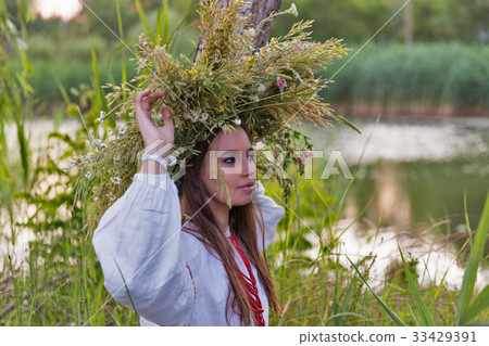 Beautiful girl in embroidery shirt and wreath 33429391