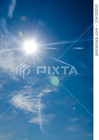 bright blue sky with the sun causing lens flare 33430850