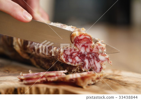 closeup shot of slicing salami with knife closeup shot of slicing salami with knife 33438844
