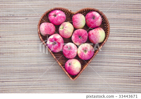 fresh apple in wicker wooden heart form basket 33443671