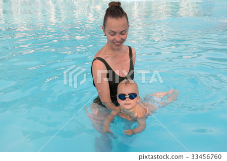 Woman teaching baby to swim 33456760