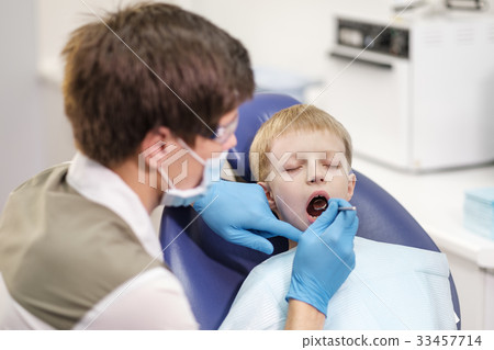 Male dentist examines the teeth of the patient Male dentist examines the teeth of the patient 33457714
