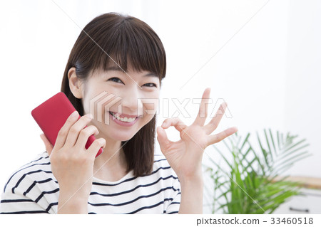一個操作智能手機的年輕女子 一個操作智能手機的年輕女子 33460518