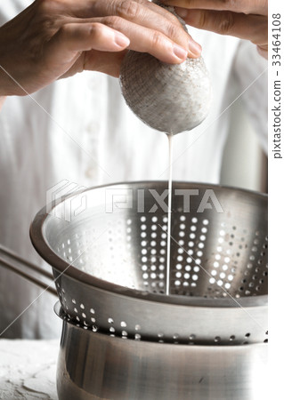 Woman squeezes the cannabis cake into a sieve Woman squeezes the cannabis cake into a sieve 33464108