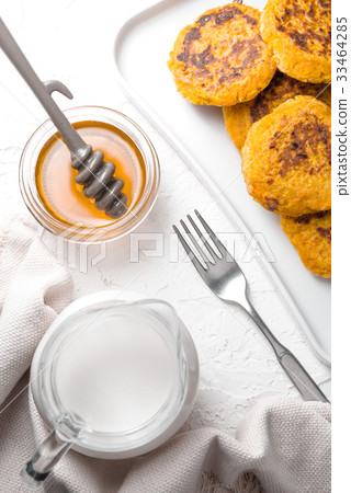 Honey, pumpkin pancakes, hemp milk on white table 33464285