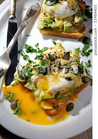 Eggs Benedict with avocado on toast 33464405