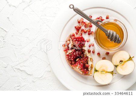 Pomegranate seeds, apples with honey on a ceramic Pomegranate seeds, apples with honey on a ceramic 33464611