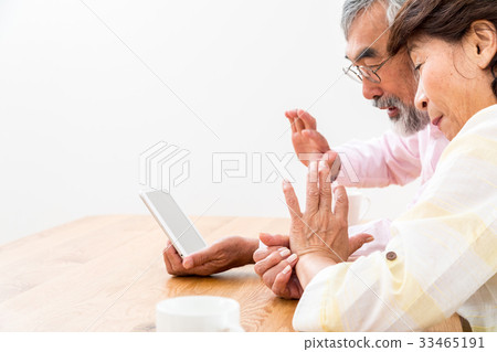 Chatting with a senior silver grandson and videophone to enjoy internet calls with family on tablet 33465191