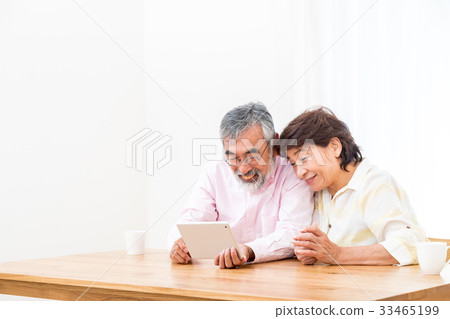 Chatting with a senior silver grandson and videophone to enjoy internet calls with family on tablet 33465199